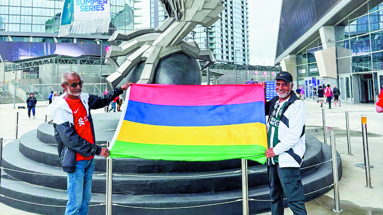 Dawood (left) with his brother Rashid (right) proudly holding the Mauritian flag.