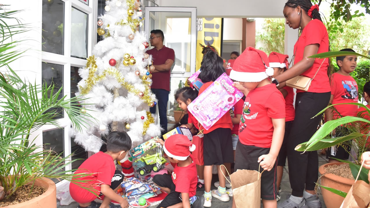 Les enfants du TejAngel’s Holiday Club déposent leurs cadeaux sous le sapin de Radio Plus, contribuant à l'opération de Noël.