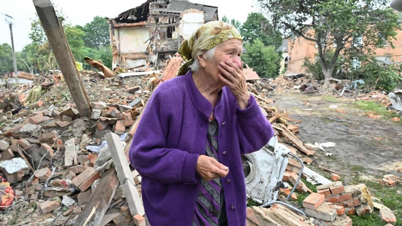 Raisa Kuval, 82 ans, réagit à côté d'un bâtiment endommagé partiellement détruit après un bombardement dans la ville de Chuguiv, à l'est de Kharkiv, en Ukraine, le 16 juillet 2022