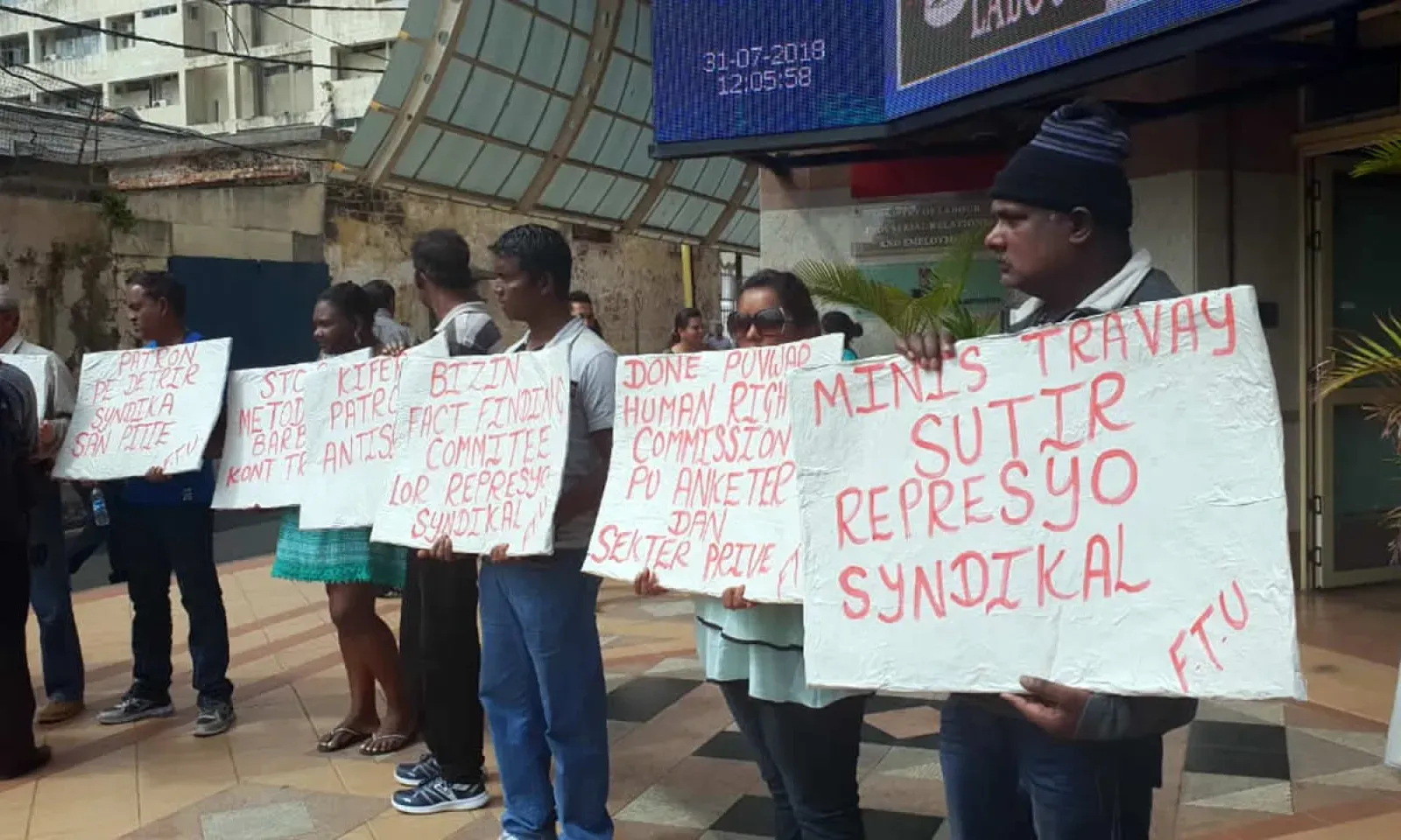 Les syndicalistes et des employés devant les locaux du ministère du Travail.