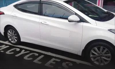 Une voiture stationnée sur un parking réservé aux deux-roues