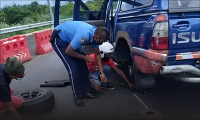 Un policier aide un automobiliste à changer un pneu