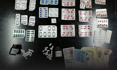 Une femme tenant son bébé et deux hommes arrêtés transportant des psychotropes