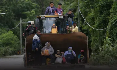 [En images] 28 000 Malaisiens fuient les inondations, des villageois évacués en pelleteuse