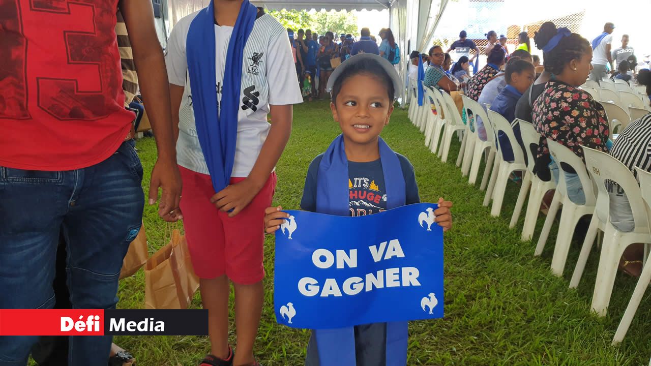 Slogan « on va gagner » dans les mains d’un petit garçon qui a accompagné ses parents au meeting.