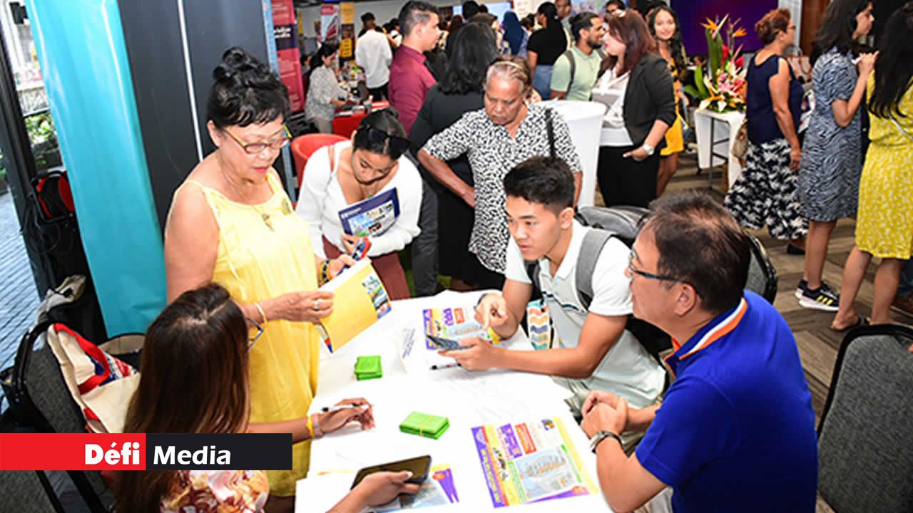 Un jeune, accompagné de ses parents, prend des informations auprès de la représentante de l’Overseas Education Centre qui offre des possibilités de cours dans les grandes universités à travers le monde.