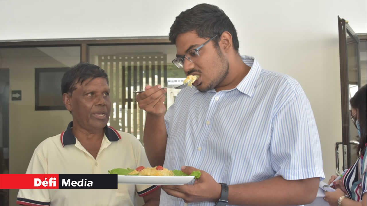 Le vloggueur culinaire Ashvin Pothano, goûtant le plat de Veeramootoo Murdamoothoo, 71 ans.