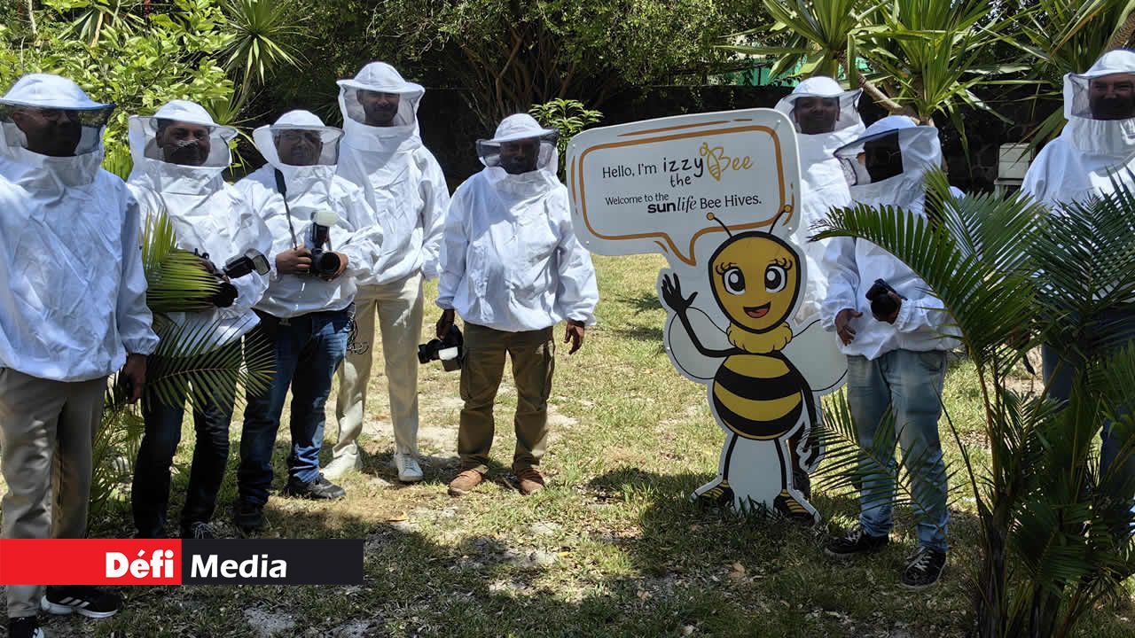 Les membres de la presse, en tenue d’apiculteur, prennent la pose pour la photo souvenir.