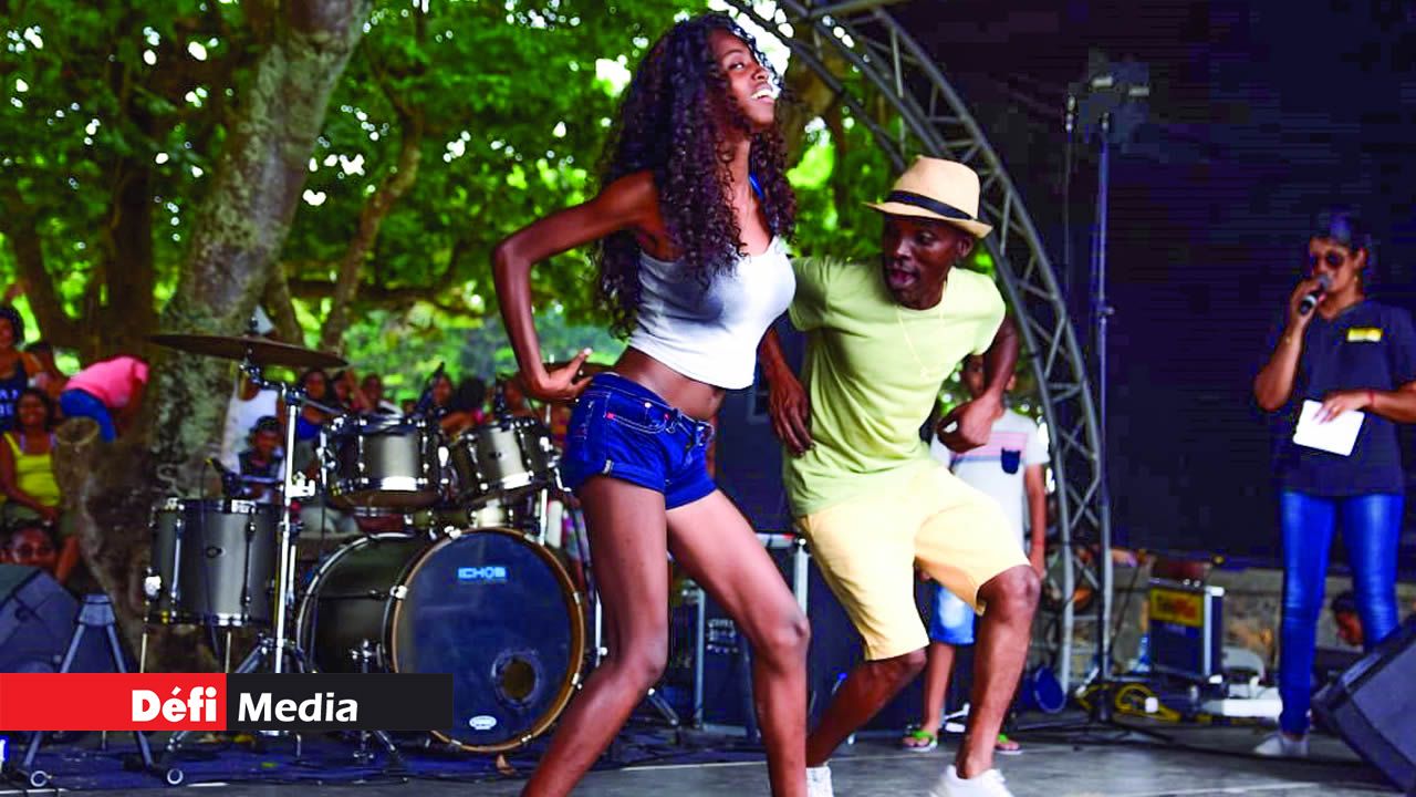 Une jeune fille faisant quelques pas de danse aux cotés de Ton Simon sur scène. Beach Tour de Radio Plus
