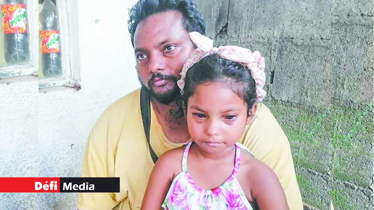 La petite fille dans les bras de son père.