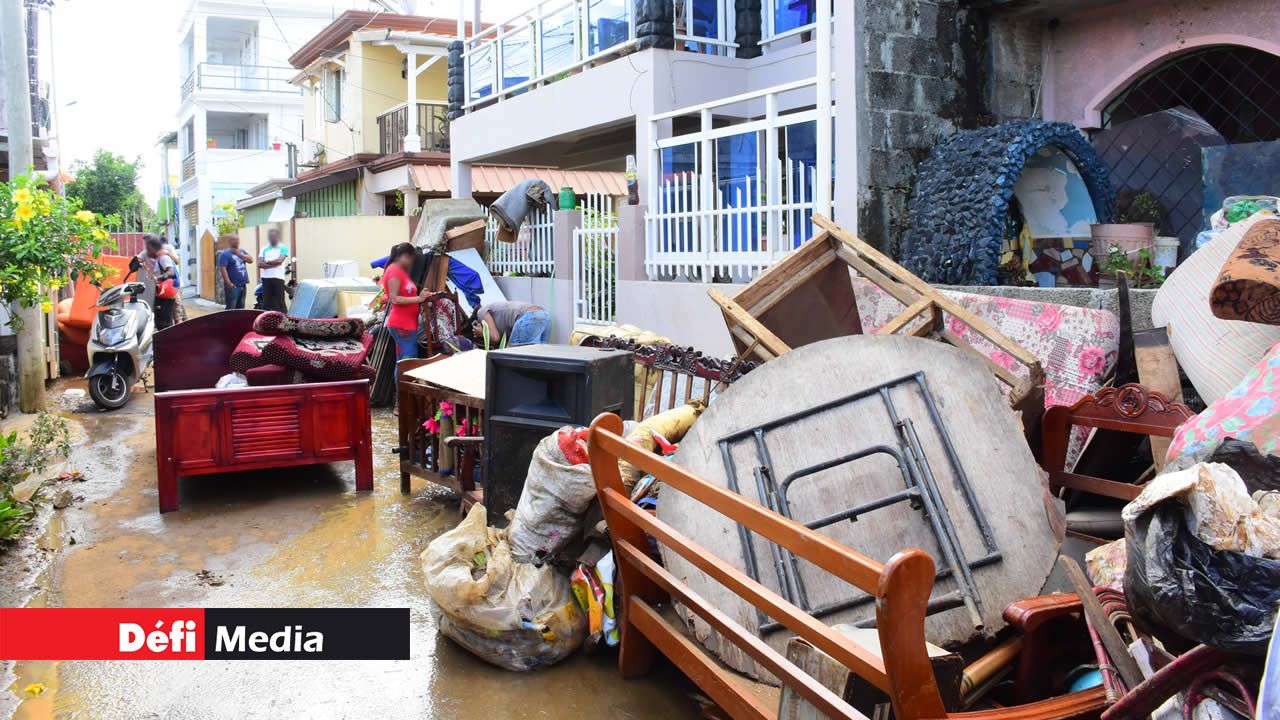 Cottage - Des sinistrés nettoyant leur demeure inondée.