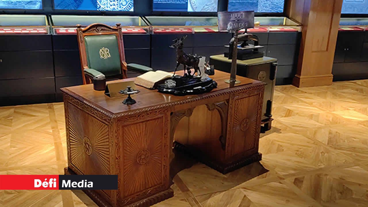 Une table de bureau avec ses accessoires et des fauteuils datant de l’époque coloniale.