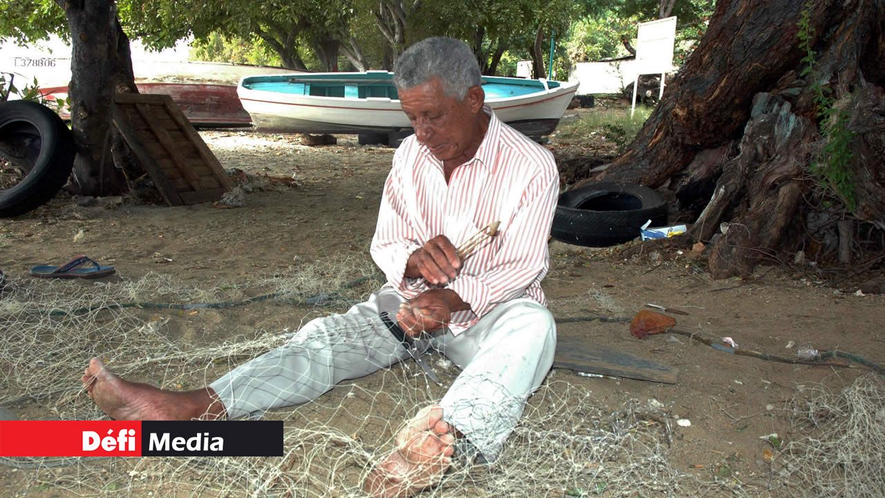Un vieux pêcheur tissant son filet avant de prendre la mer. pêcheur