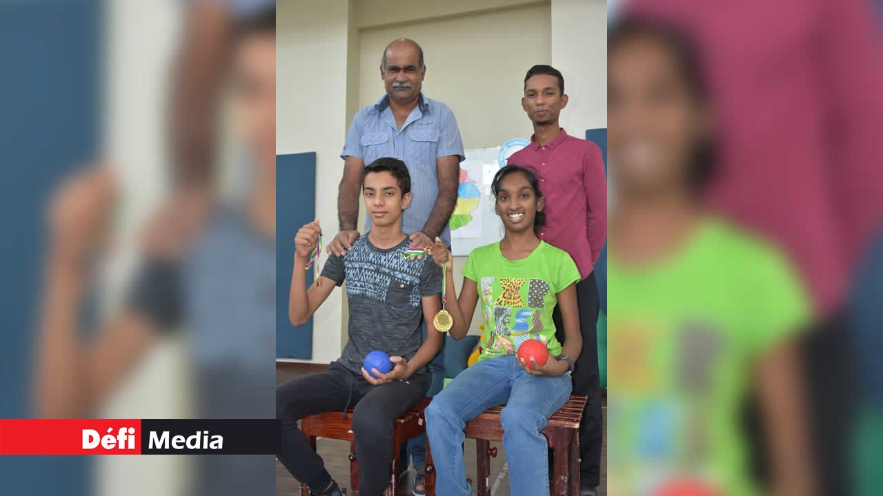 Aftaab Gokhool et Poovanjanee Bhundoo (assis), posant en compagnie de leurs éducateurs physiques et montrant fièrement leurs médailles. Independence autrement