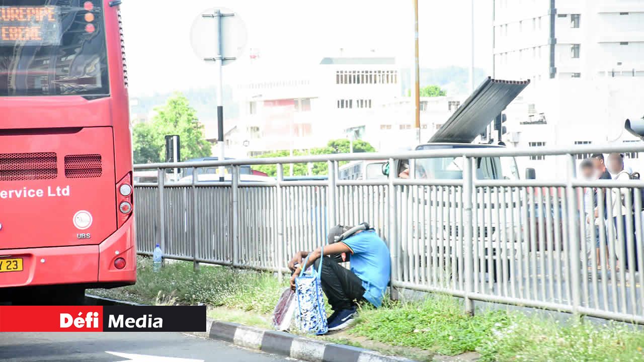 Cet homme assis sur le terre-plein central de l’autoroute semble peu conscient du danger avoisinant.