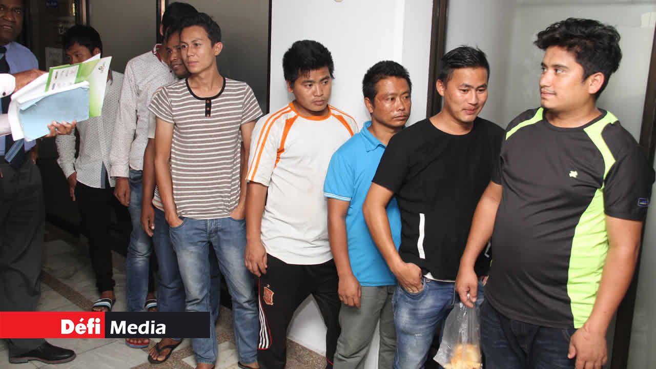 Des travailleurs étrangers au Passport and Immigration Office.