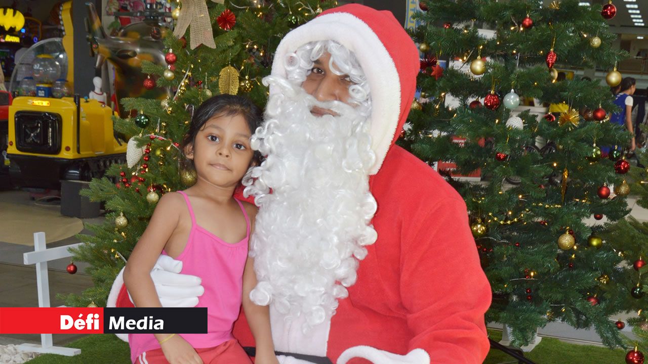Le fameux Père Noël posant avec les enfants pour des photos.