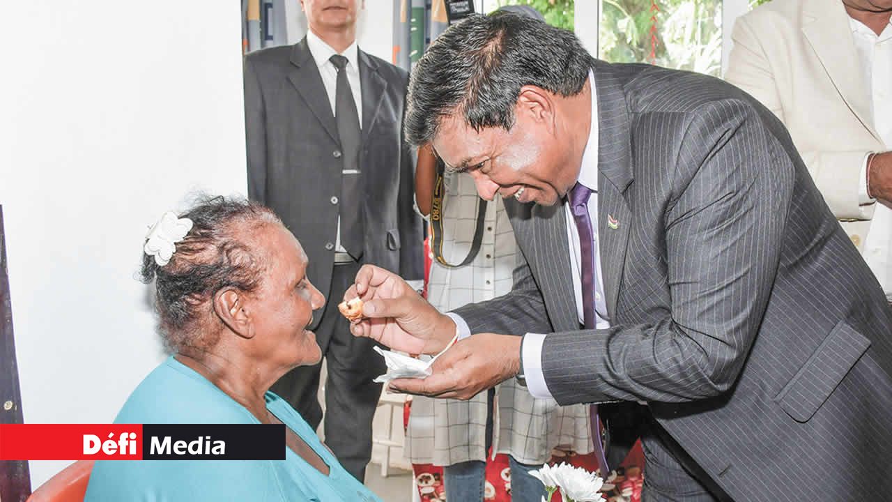 Le président offrant une bouchée à Shanti Teepoo après avoir inauguré son nouveau chez-soi.