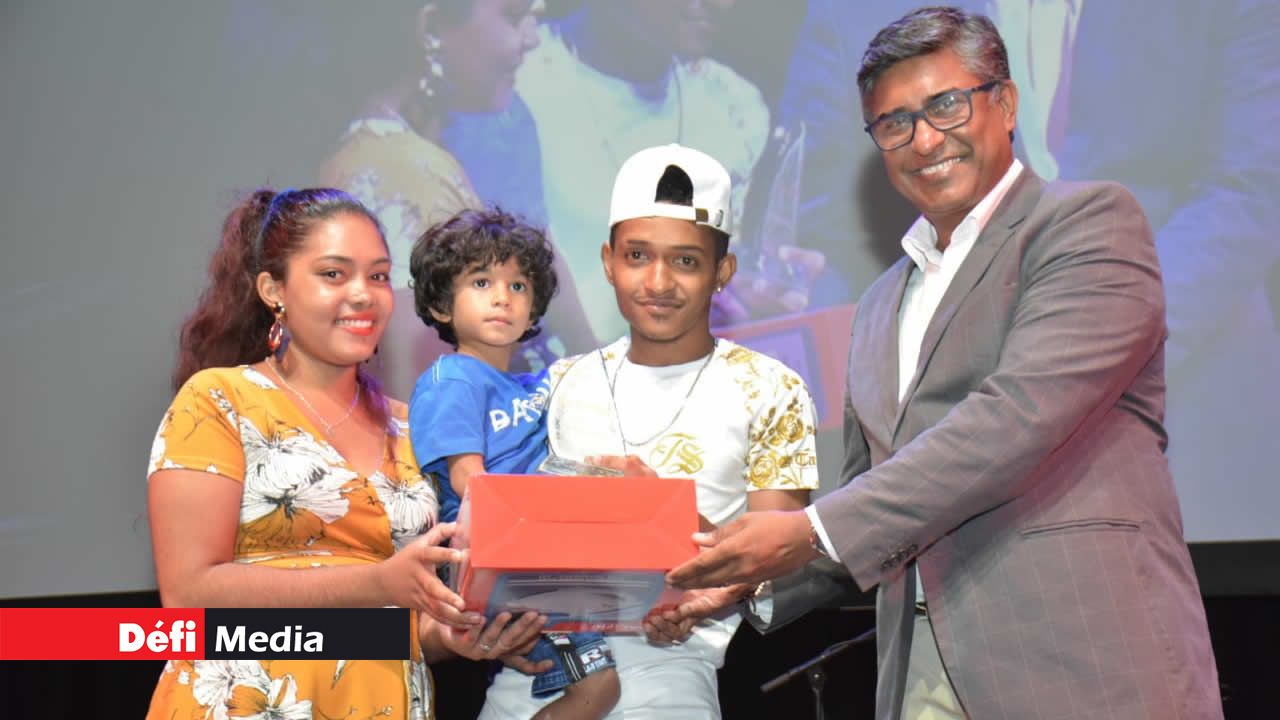 Prem Sewpaul, responsable de communication chez Air Mauritius, remet le Best Duet Tik Tok Award à Julien Antonio et Gwendolyn Rene, accompagnés de leur fils. Compétition Tik Tok de Radio Plus