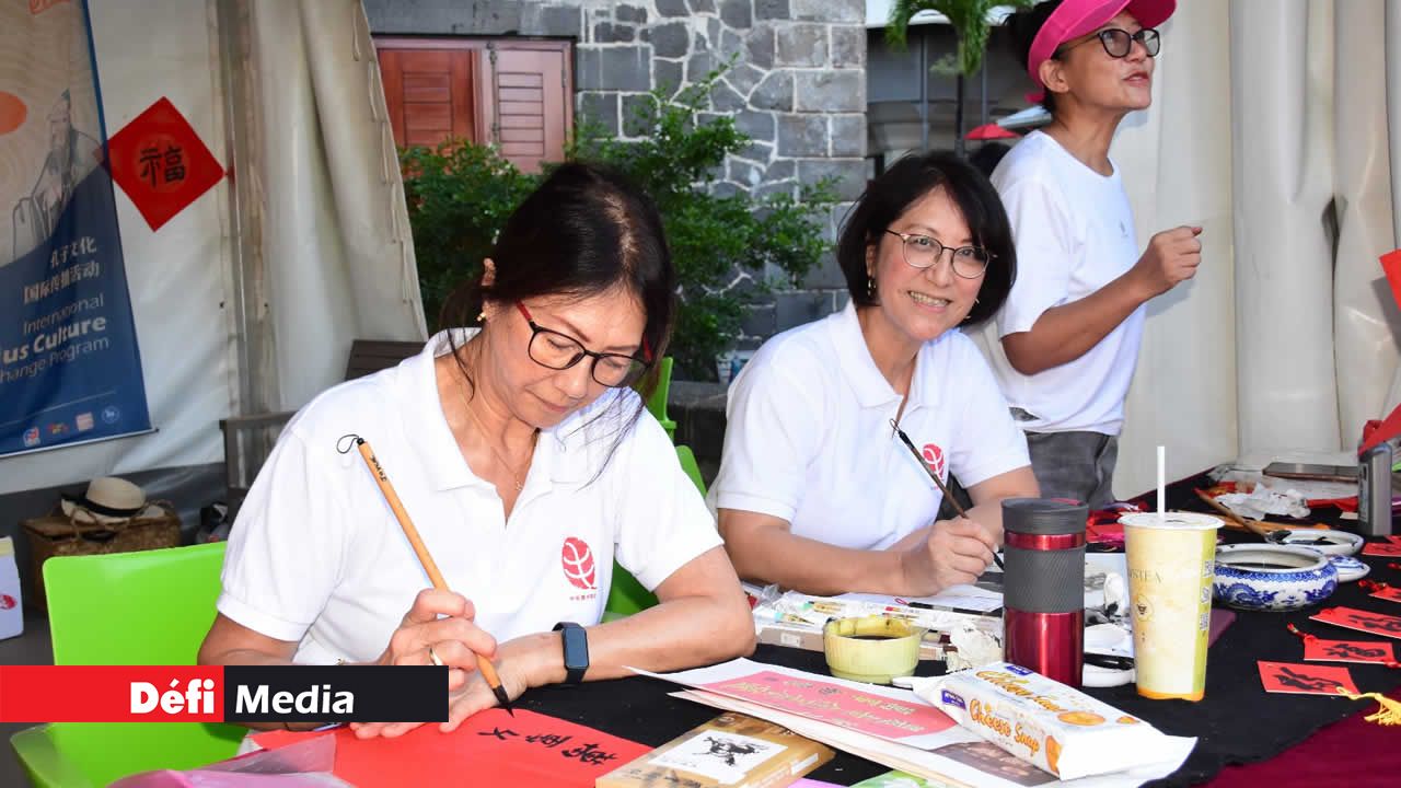 Des participantes à la parade exécutent une démonstration de calligraphie chinoise, maniant avec précision plumes et encre pour partager cet art ancestral.