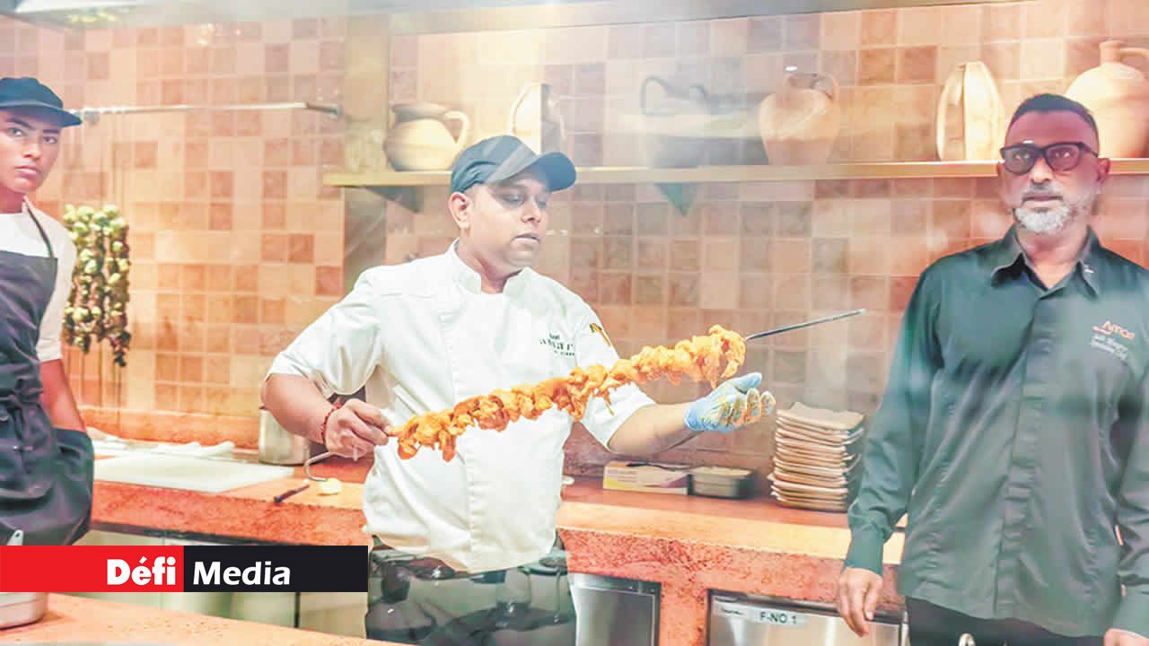 À travers la baie vitrée au restaurant AMARI by Vineet, on peut apercevoir la préparation et la mise en place des plats de la cuisine indienne sous la supervision du chef Subi Mungroo.
