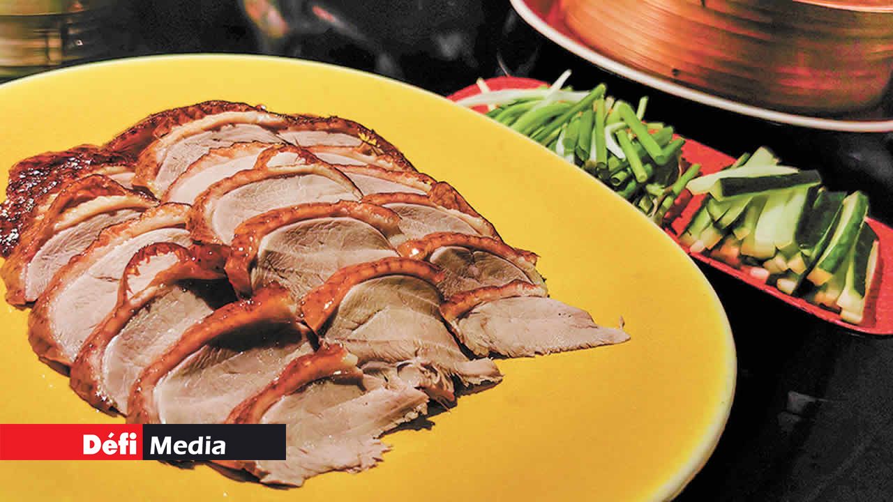 Le canard laqué coupé en tranches avec précision par le chef Wang.