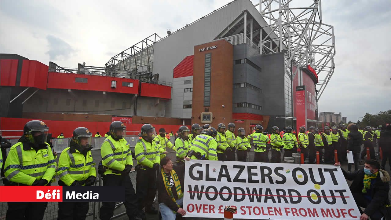 ? Des policiers sont en faction alors que des manifestants protestent contre les propriétaires de Manchester United devant Old Trafford le 13 mai 2021 Protestation
