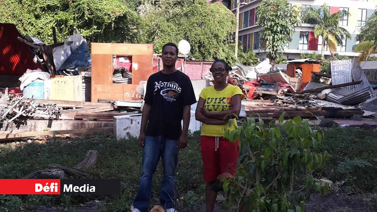 Marie-Lourdes Bengali
devant sa case en tôle démolie.