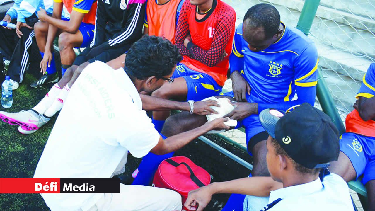 Linganaden Munien et Emmanuel Collard prodiguent les premiers soins à Rock Durand.