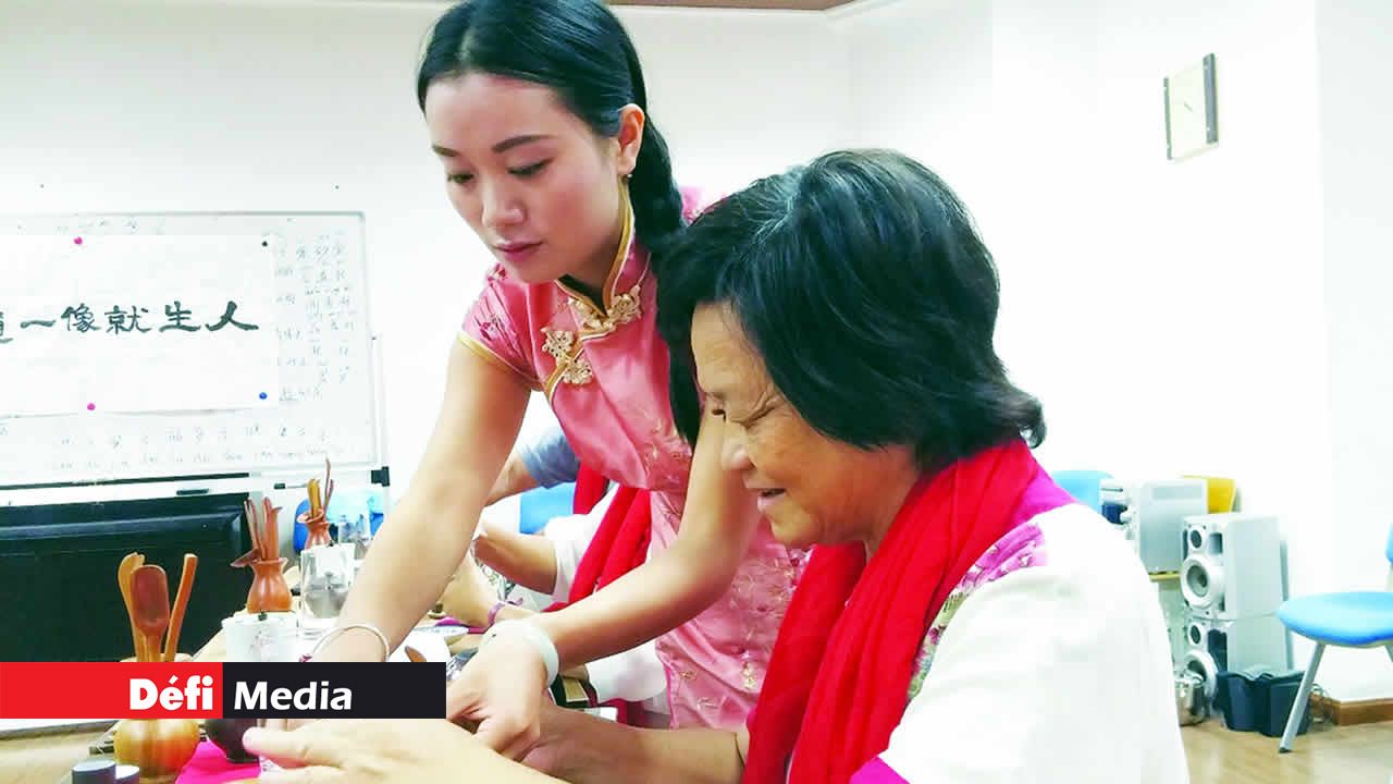 Bang Kok Lam apprend à rincer la vaisselle pour le thé aux fleurs.